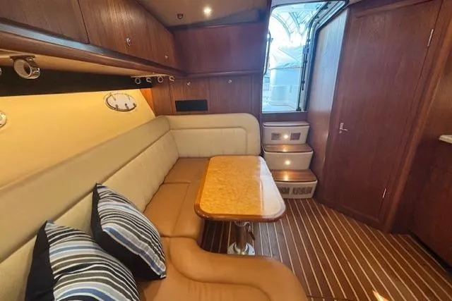 The Riddler Yacht Photos Pics Interior of 2009 Tiara Yachts 3600 Open, featuring a cozy seating area and wooden accents.