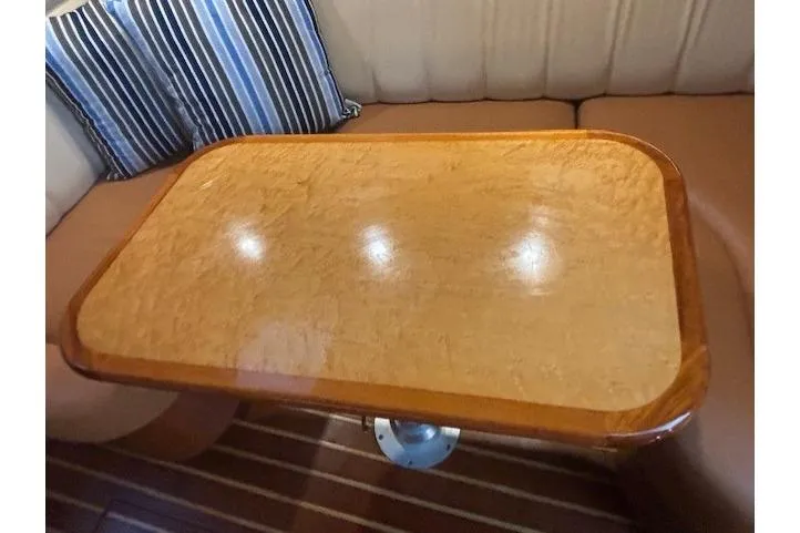 The Riddler Yacht Photos Pics 2009 Tiara Yachts 3600 Open interior with polished wooden table and striped cushions.