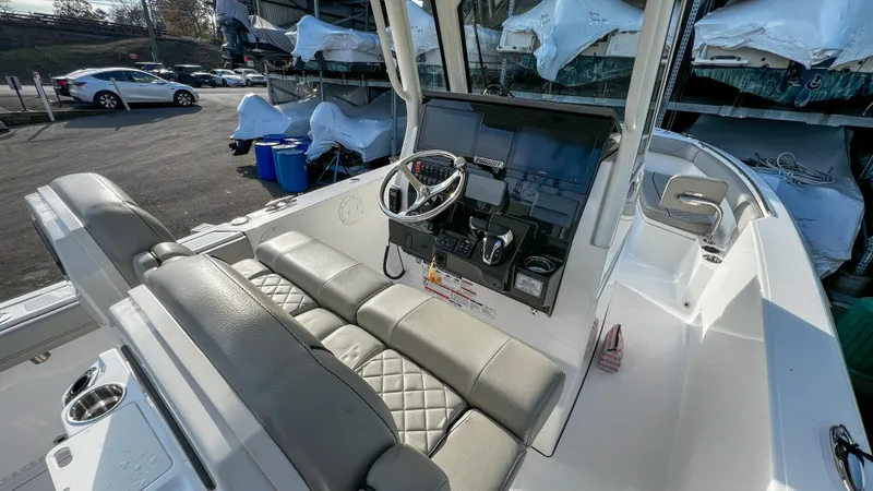  Yacht Photos Pics 2022 Pursuit S 268 boat interior with steering wheel and cushioned seating.