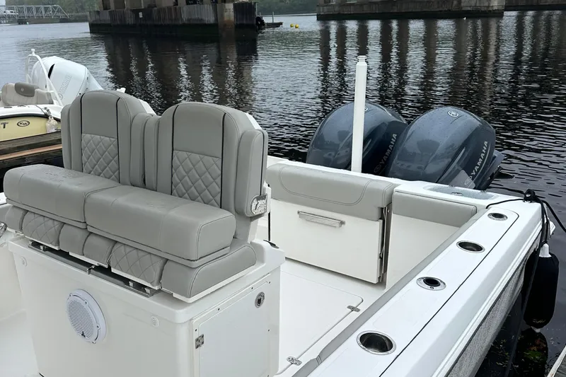  Yacht Photos Pics 2022 Pursuit S 268 boat with dual engines and cushioned seating on a calm river.