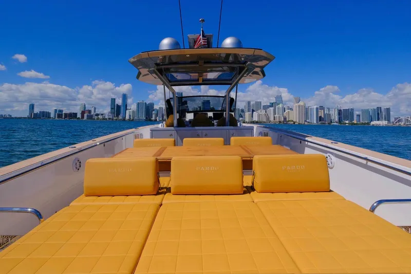 Seaduction Yacht Photos Pics 2023 Pardo Yachts 43 with yellow seating, city skyline in background, sunny day.