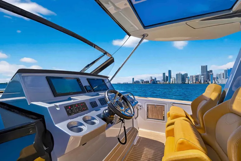Seaduction Yacht Photos Pics 2023 Pardo Yachts 43 helm with city skyline view, featuring luxurious seating and modern controls.