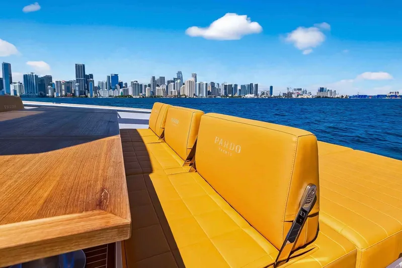 Seaduction Yacht Photos Pics Luxurious 2023 Pardo Yachts 43 with city skyline view, featuring elegant seating and wooden table.