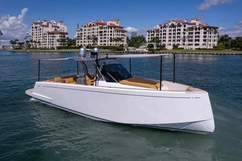 Seaduction Yacht Photos Pics 2023 Pardo Yachts 43 cruising near luxury waterfront apartments under a clear blue sky.