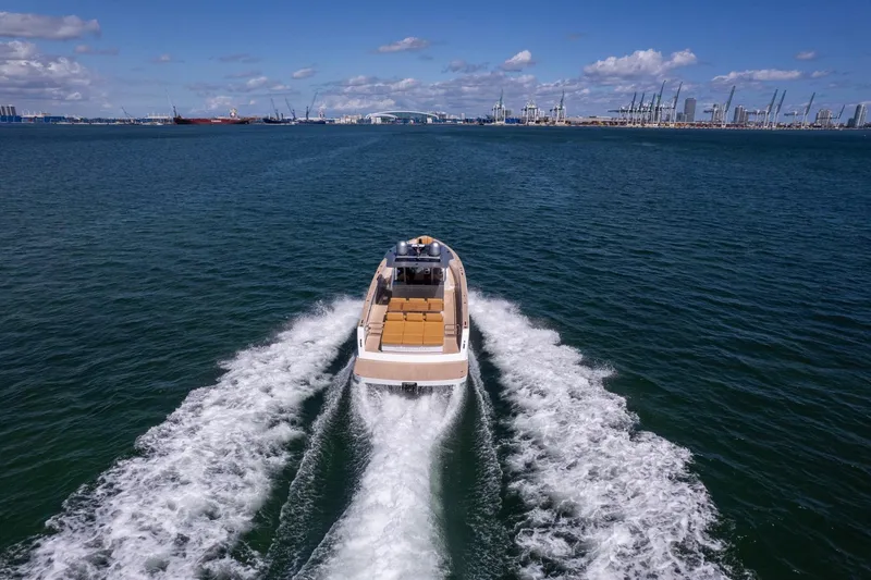 Seaduction Yacht Photos Pics 2023 Pardo Yachts 43 cruising on open water with city skyline in background.