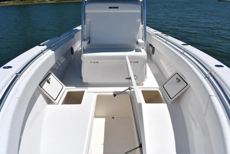  Yacht Photos Pics 2024 Contender 28 Tournament boat interior with storage compartments and seating on calm water.