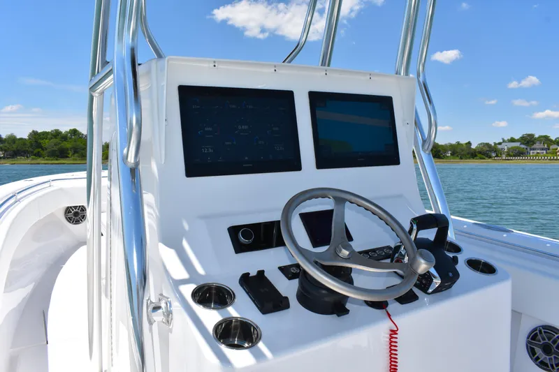  Yacht Photos Pics 2024 Contender 28 Tournament boat dashboard with dual screens and steering wheel, on a sunny day.
