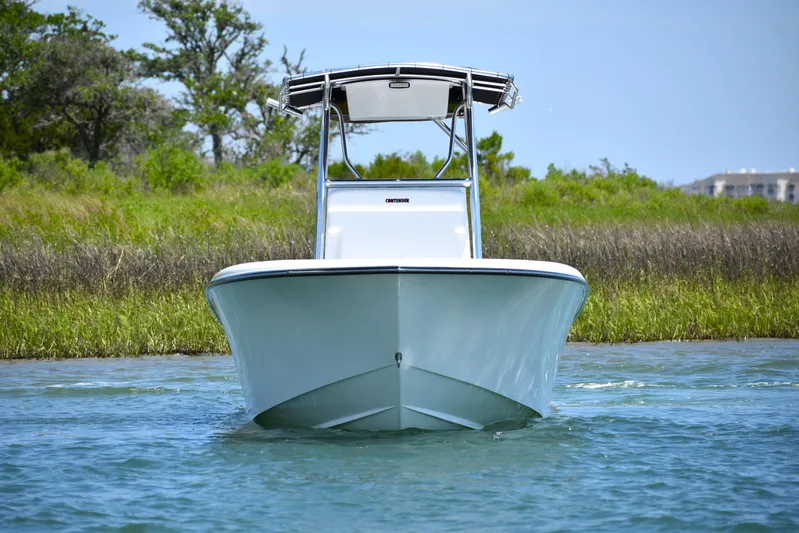  Yacht Photos Pics 2024 Contender 28 Tournament boat on water, front view, with lush greenery background.