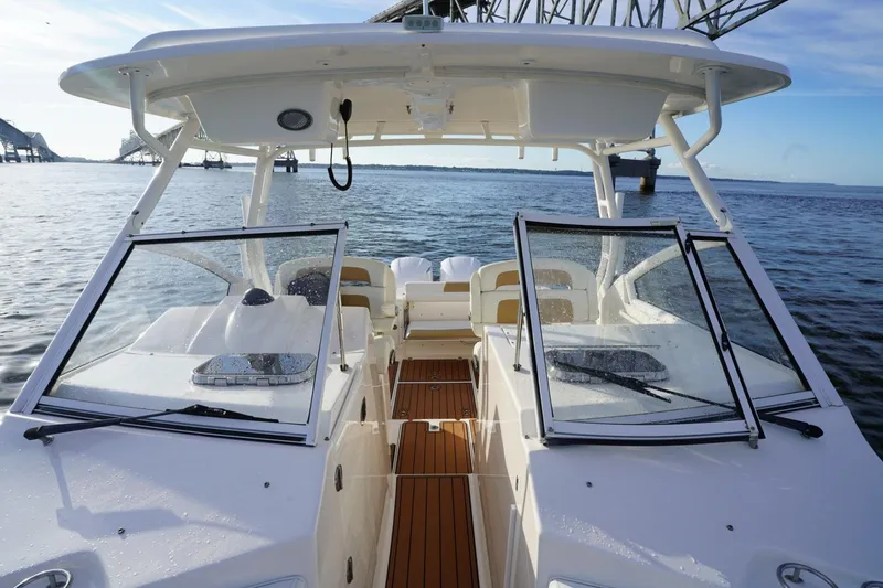  Yacht Photos Pics 2016 Edgewater 280 CX boat on water, featuring open deck and windshield.