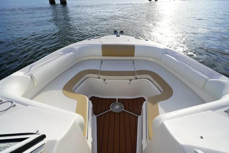  Yacht Photos Pics 2016 Edgewater 280 CX boat interior with cushioned seating and wooden deck, on calm water.