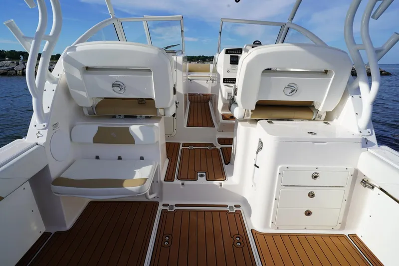  Yacht Photos Pics 2016 Edgewater 280 CX boat interior with seating and wooden flooring, docked by the water.