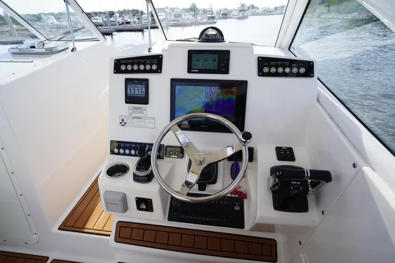  Yacht Photos Pics Helm of 2016 Edgewater 280 CX boat with navigation instruments and steering wheel.