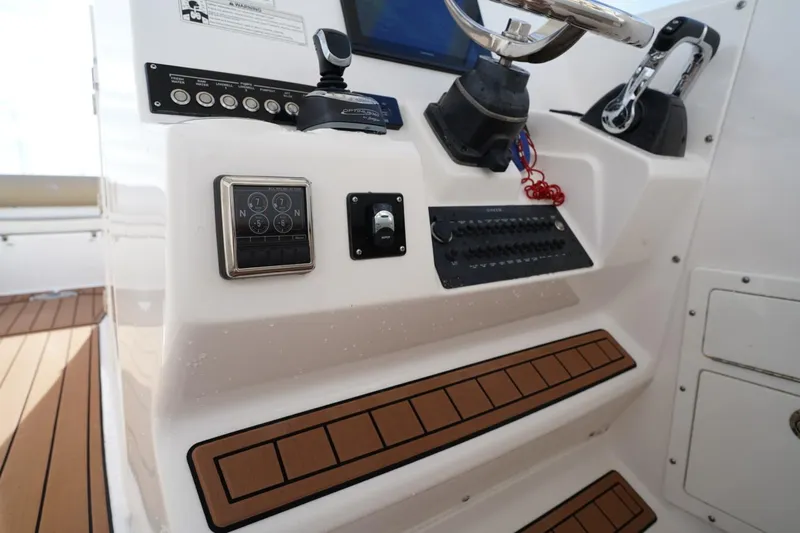  Yacht Photos Pics Control panel of a 2016 Edgewater 280 CX boat with steering wheel and switches.