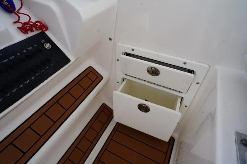  Yacht Photos Pics 2016 Edgewater 280 CX boat interior with open storage drawers and control panel.