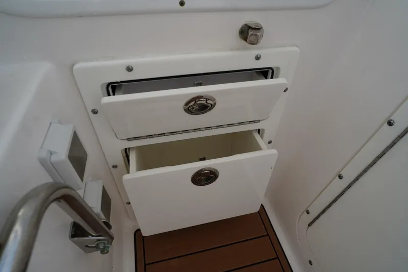  Yacht Photos Pics Storage compartments on a 2016 Edgewater 280 CX boat, featuring two open drawers.