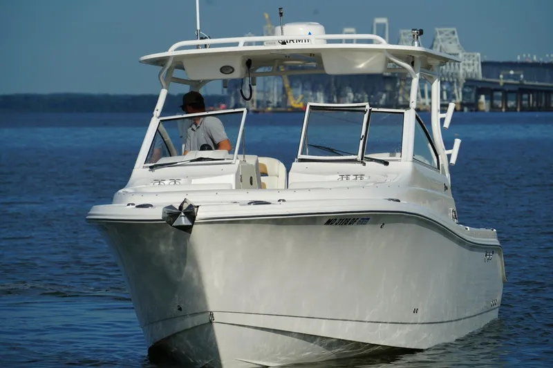  Yacht Photos Pics 2016 Edgewater 280 CX boat cruising on calm water near a bridge.