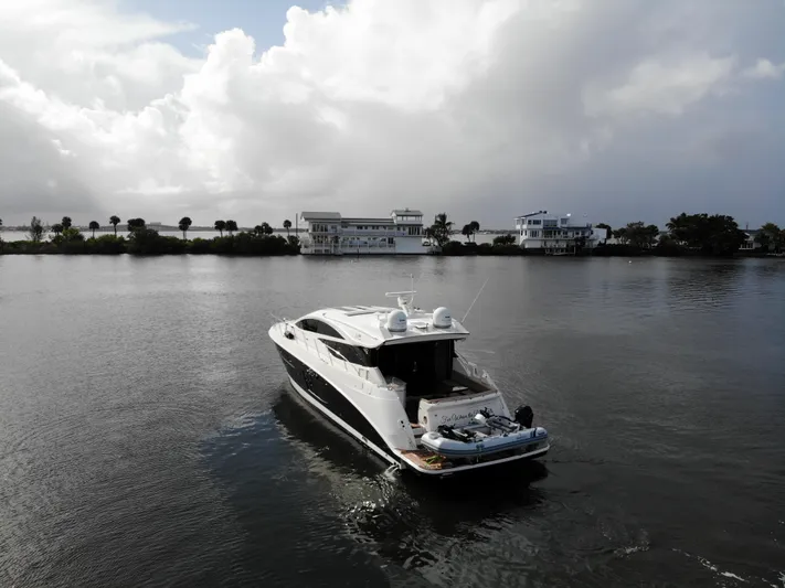 For Whom The Bell Tolls Yacht Photos Pics 2017 Sea Ray L590 yacht cruising on a calm waterway under a cloudy sky.