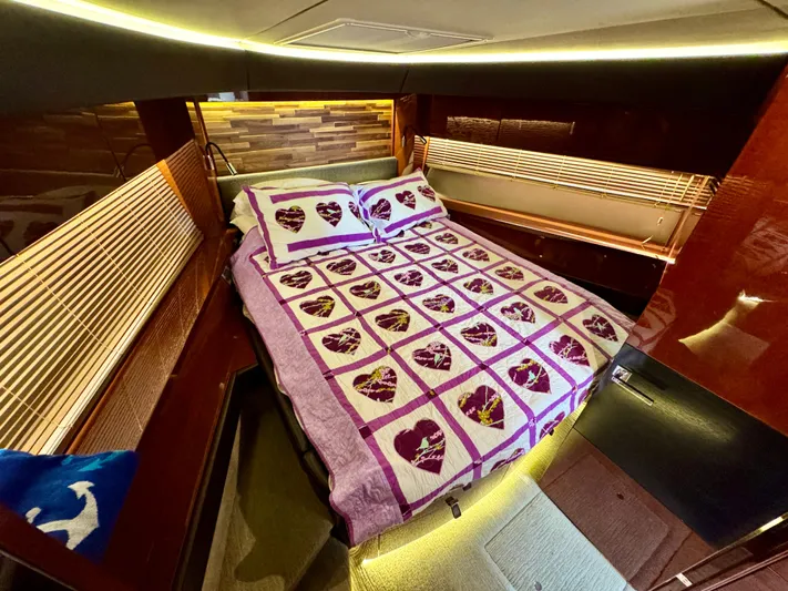 For Whom The Bell Tolls Yacht Photos Pics Luxurious 2017 Sea Ray L590 yacht cabin with heart-patterned bedding and ambient lighting.