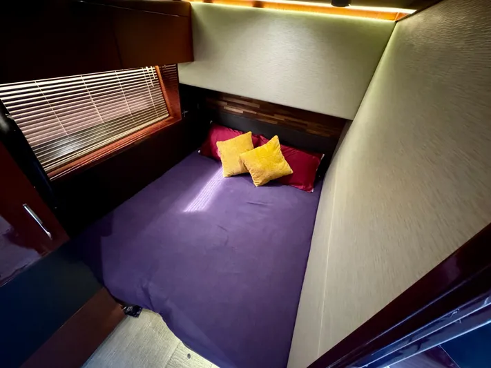 For Whom The Bell Tolls Yacht Photos Pics Luxurious bedroom interior of 2017 Sea Ray L590 yacht with cozy bedding and ambient lighting.