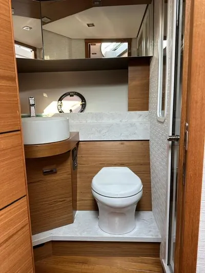  Yacht Photos Pics 2022 Tiara Yachts C39 Coupe bathroom with modern fixtures and wood accents.