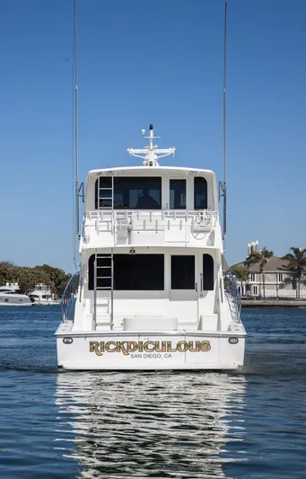 Triumph Yacht Photos Pics 1999 Viking 58 Enclosed Bridge yacht on calm water, rear view.