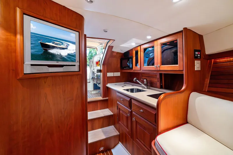 Capri Yacht Photos Pics Luxurious interior of 2008 Hinckley Talaria 38R Convertible yacht with wood finish and modern amenities.