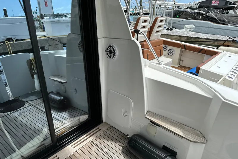 Andalucia Yacht Photos Pics 2017 Jeanneau NC 11 boat interior with wooden deck and seating area at marina.