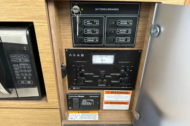 Andalucia Yacht Photos Pics Electrical control panel on a 2017 Jeanneau NC 11 boat, featuring battery breakers and generator controls.