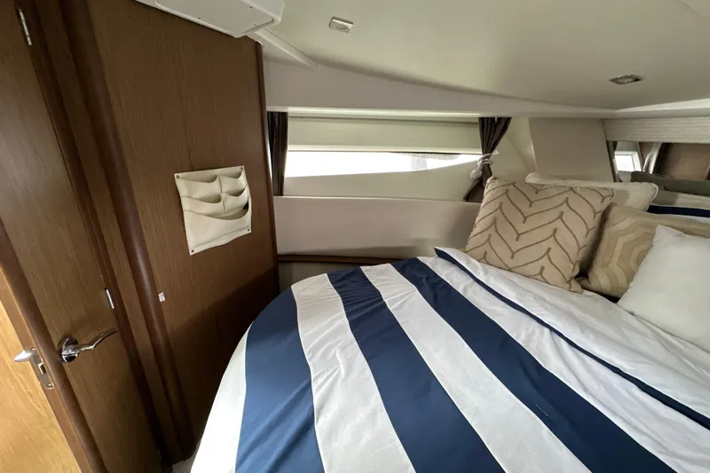 Andalucia Yacht Photos Pics 2017 Jeanneau NC 11 cabin interior with striped bedding and decorative pillows.