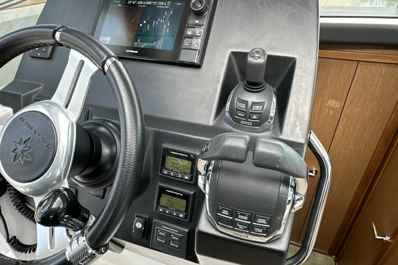 Andalucia Yacht Photos Pics Control panel of a 2017 Jeanneau NC 11 boat with steering wheel and navigation system.