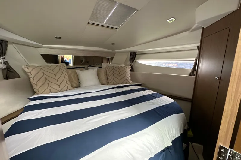 Andalucia Yacht Photos Pics 2017 Jeanneau NC 11 cabin interior with striped bedding and decorative pillows.
