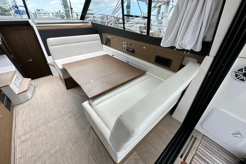 Andalucia Yacht Photos Pics Interior of 2017 Jeanneau NC 11 yacht with elegant seating and wooden table.