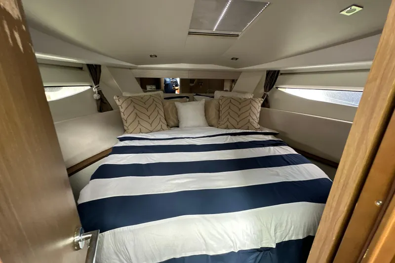 Andalucia Yacht Photos Pics Luxurious cabin interior of 2017 Jeanneau NC 11 with striped bedding and cushions.