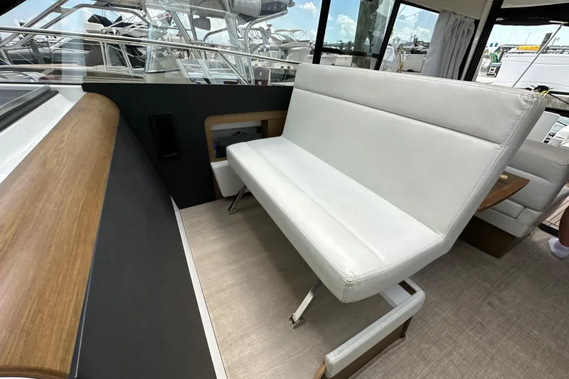 Andalucia Yacht Photos Pics Interior of 2017 Jeanneau NC 11 yacht with white seating and wood accents.