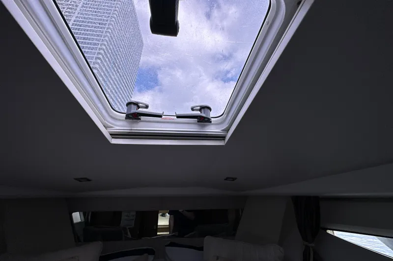 Andalucia Yacht Photos Pics Interior view of 2017 Jeanneau NC 11 boat with skylight and cityscape.