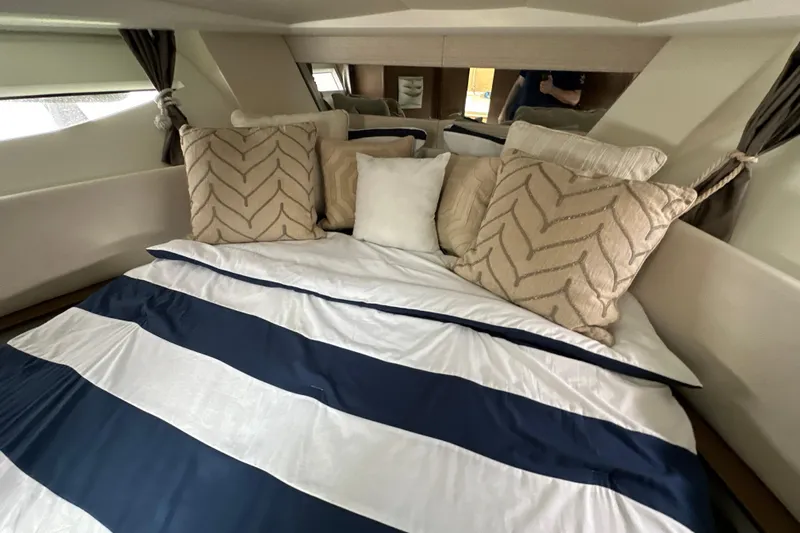 Andalucia Yacht Photos Pics Cozy cabin interior of 2017 Jeanneau NC 11 with striped bedding and decorative pillows.