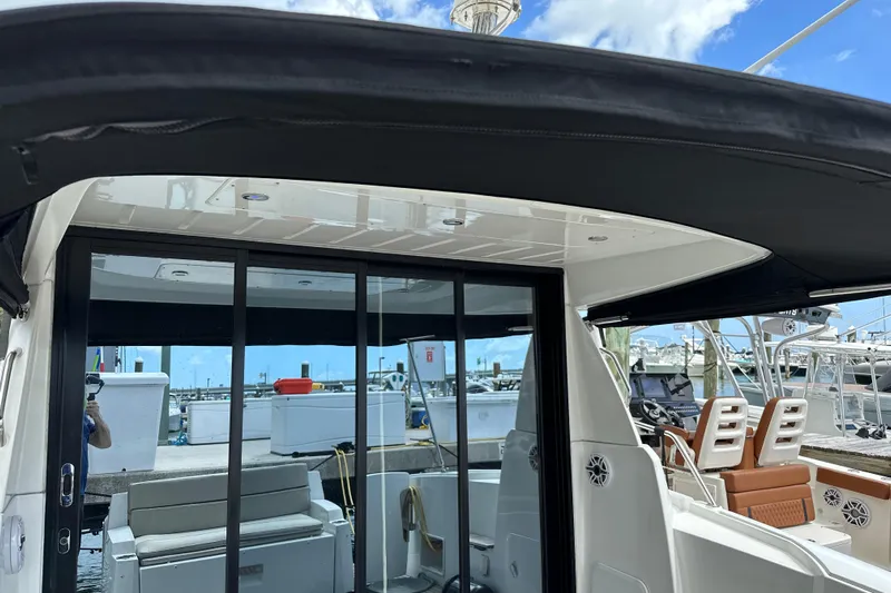 Andalucia Yacht Photos Pics 2017 Jeanneau NC 11 boat interior with sliding glass doors and seating at a marina.