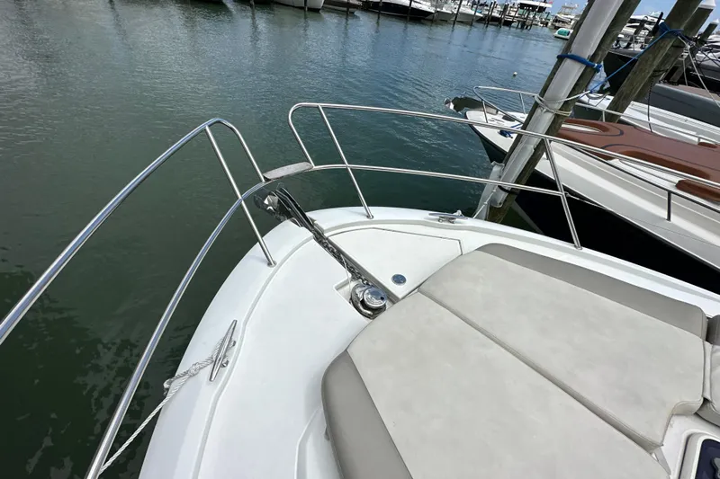 Andalucia Yacht Photos Pics Bow of 2017 Jeanneau NC 11 yacht with sunpad and railing, docked in marina.