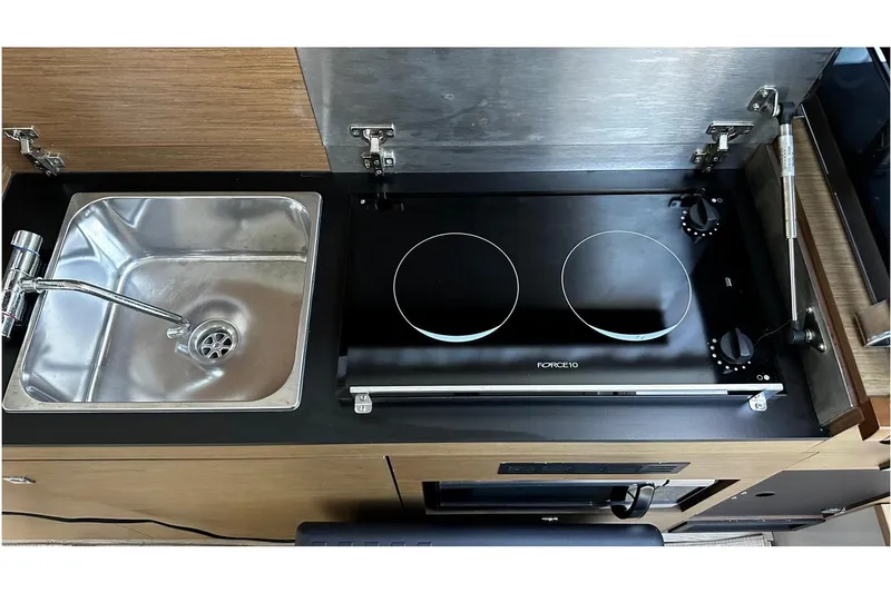 Andalucia Yacht Photos Pics Kitchen area of 2017 Jeanneau NC 11 with sink and dual-burner stove.