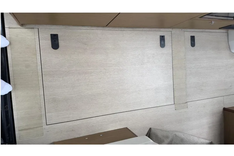 Andalucia Yacht Photos Pics Interior view of 2017 Jeanneau NC 11 boat, featuring wooden paneling and storage compartments.