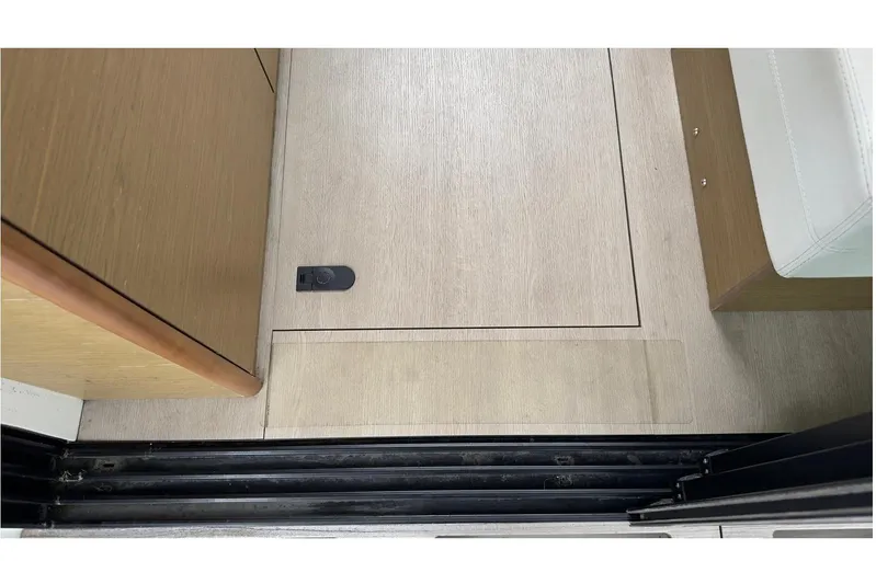 Andalucia Yacht Photos Pics 2017 Jeanneau NC 11 interior floor with wooden finish and storage compartment.