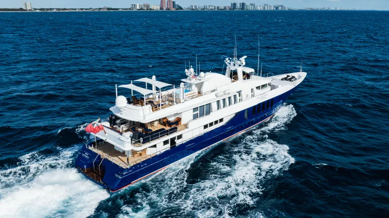 High Occupancy Yacht Photos Pics Luxurious 1989 Oceanfast Custom yacht cruising on open sea with city skyline backdrop.