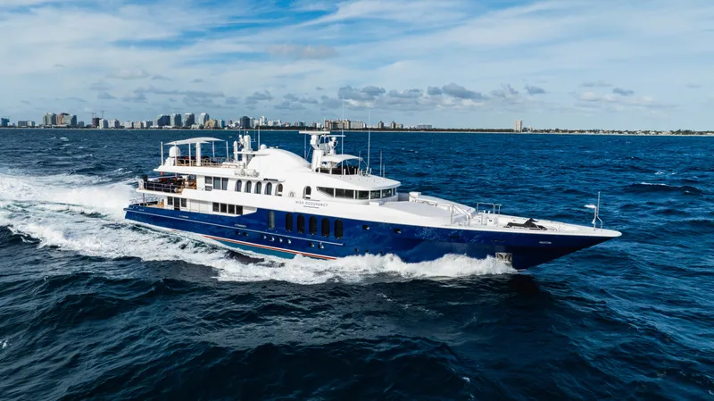 High Occupancy Yacht Photos Pics Luxurious 1989 Oceanfast Custom yacht cruising on open sea with city skyline in background.