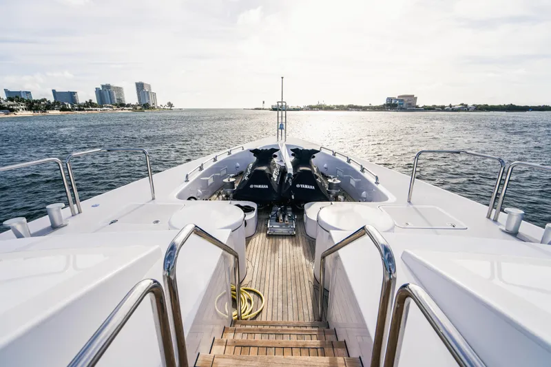 High Occupancy Yacht Photos Pics Oceanfast Custom 1989 yacht deck with Yamaha jet skis, overlooking a serene waterfront view.