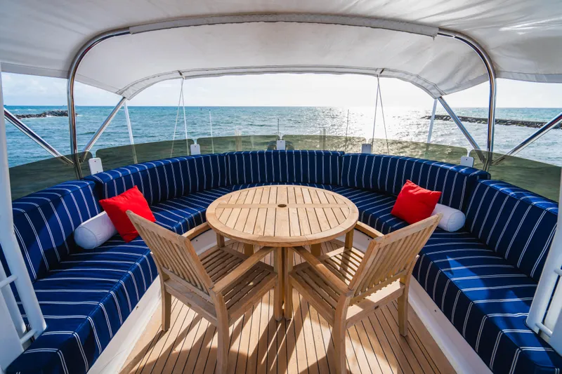 High Occupancy Yacht Photos Pics Luxurious Oceanfast Custom yacht deck with striped seating, wooden table, and ocean view, 1989 model.