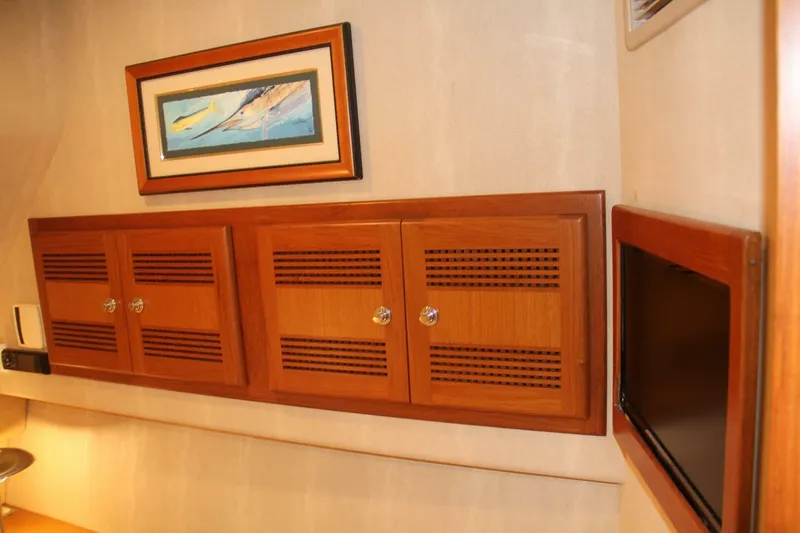 Merry Yacht Yacht Photos Pics Interior of 2004 Cabo 48 Flybridge with wooden cabinets and framed artwork.