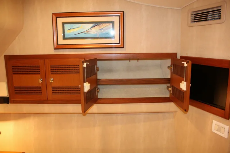 Merry Yacht Yacht Photos Pics 2004 Cabo 48 Flybridge interior with open wooden cabinet and framed fish artwork.