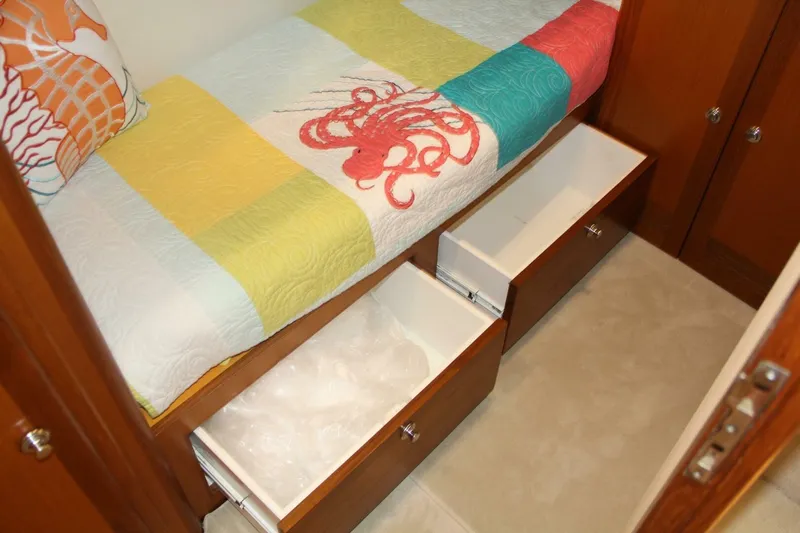 Merry Yacht Yacht Photos Pics 2004 Cabo 48 Flybridge cabin with colorful bedding and open storage drawers.