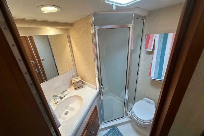Merry Yacht Yacht Photos Pics Luxurious bathroom in 2004 Cabo 48 Flybridge yacht with shower and modern amenities.