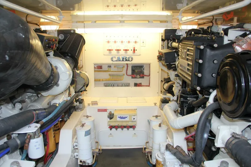 Merry Yacht Yacht Photos Pics Engine room of 2004 Cabo 48 Flybridge yacht, showcasing dual engines and control systems.